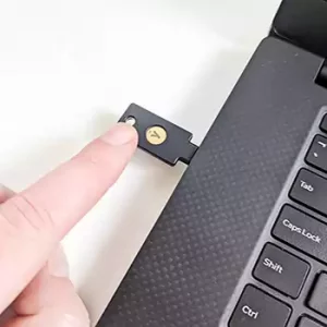 Touching the YubiKey 5C NFC inserted into the laptop USB-C port..